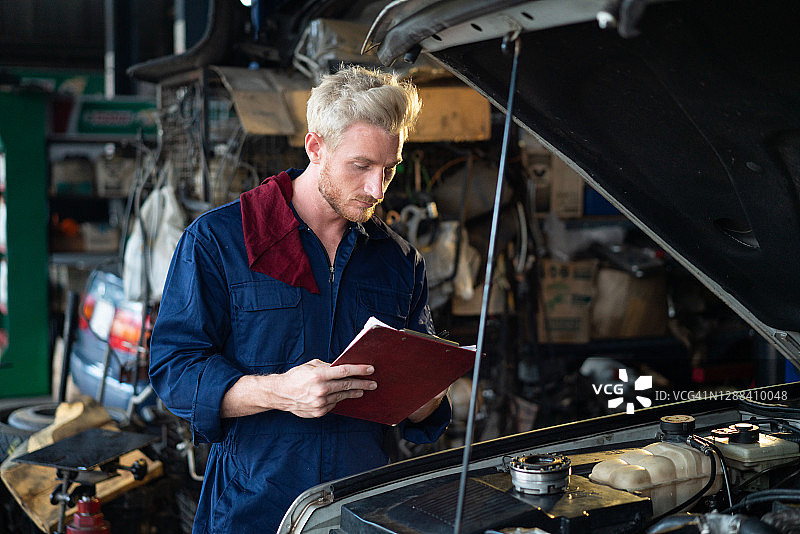 汽车维护与修理：机械师在清单上记录图片素材