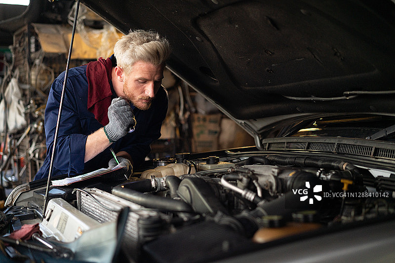 汽车维护与修理：机械师在清单上记录图片素材