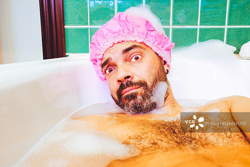 戴着浴帽泡澡的男子肖像图片素材
