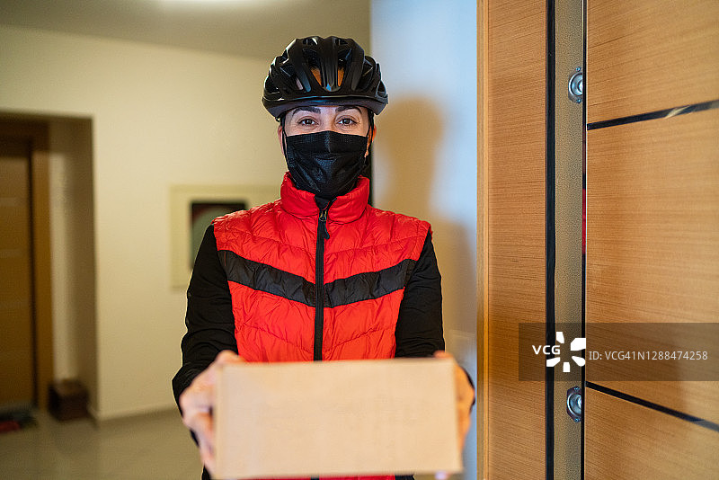 骑自行车送货上门的年轻女快递员图片素材