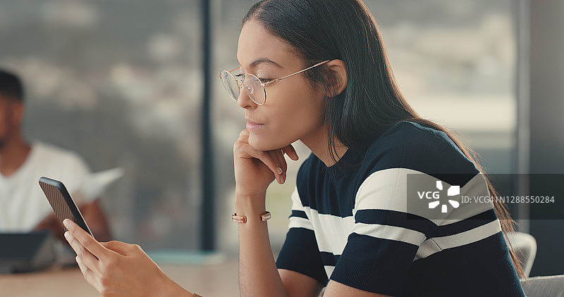 在手机上协调她的工作日图片素材