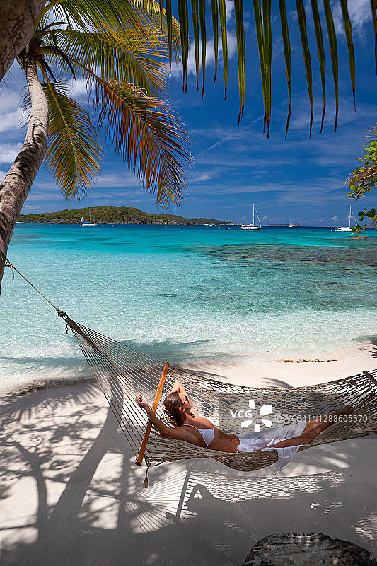 在热带海滩吊床上放松的女人图片素材