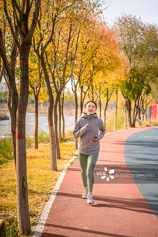 在城市公园跑步的年轻亚洲女性图片素材