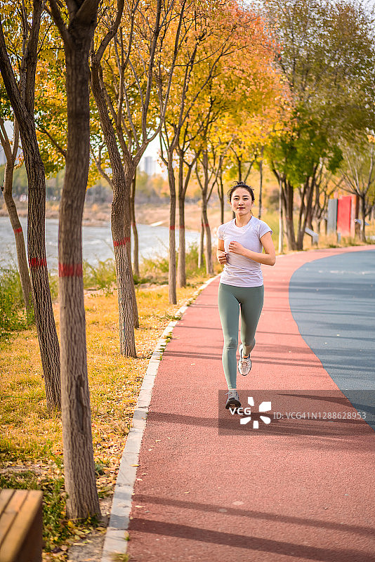 在城市公园跑步的年轻亚洲女性图片素材