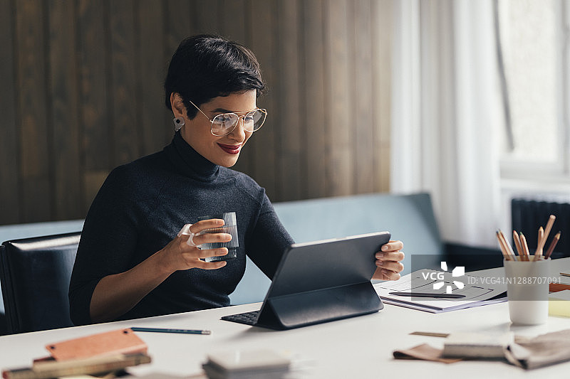 在设计工作室：建筑师在办公室里用平板电脑观看内容图片素材