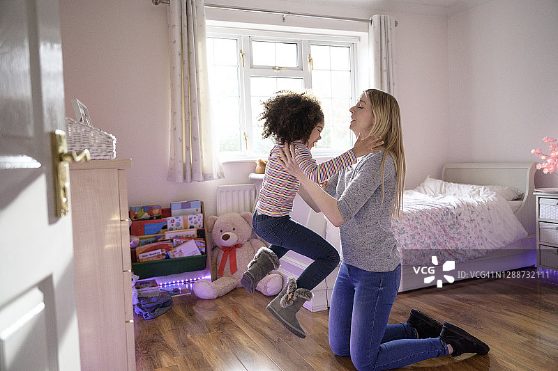 母亲在家和活泼的小女儿玩耍图片素材