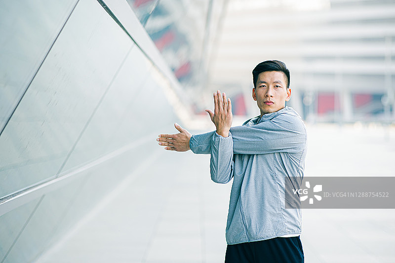 男子在城市里伸展手臂图片素材