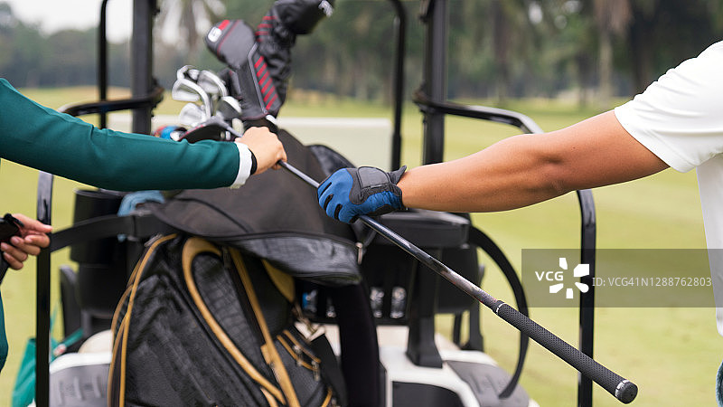 男性高尔夫球手、球童和高尔夫球车的手部特写图片素材