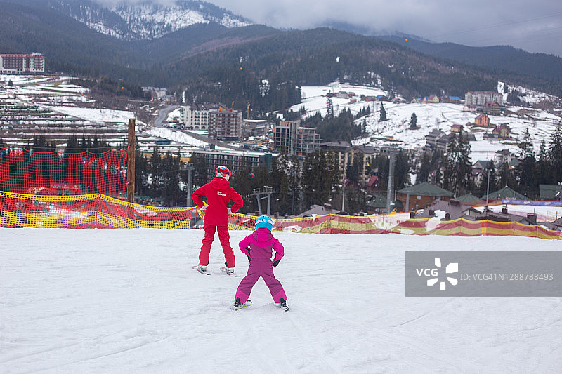 孩子和教练一起学习滑雪图片素材
