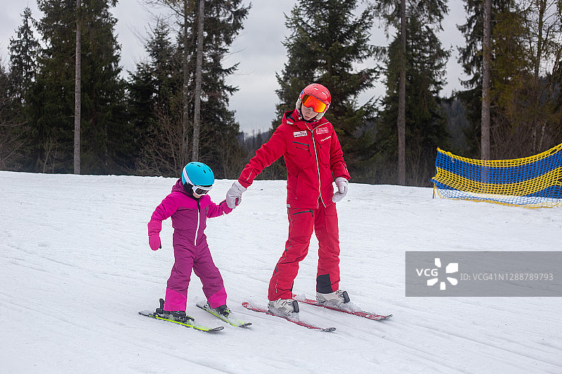 孩子和教练一起学习滑雪图片素材