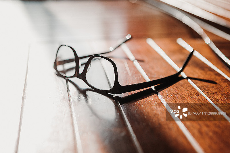 家中木质表面的眼镜与阴影图片素材