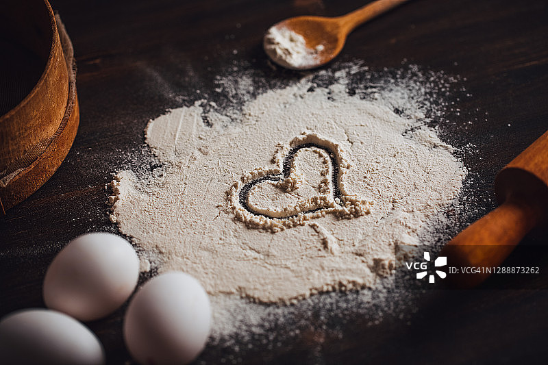 在乡村木桌面的面粉上制作心形图片素材
