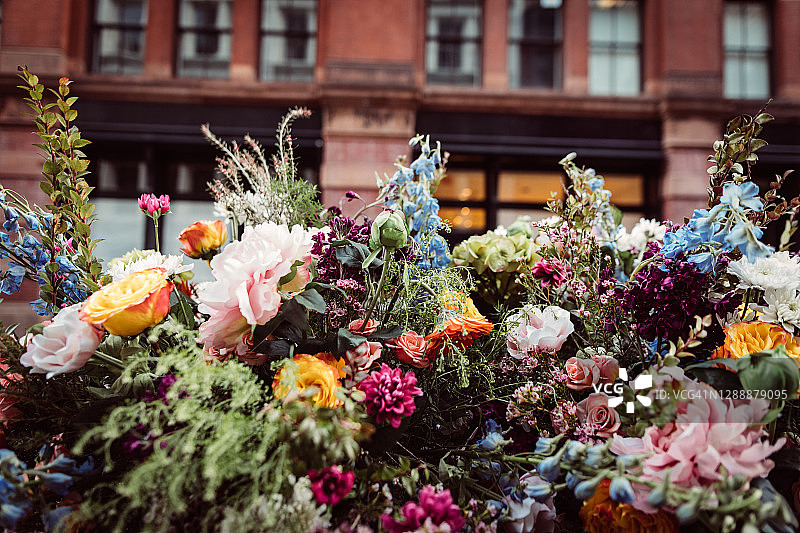 冬季纽约街头，一辆美丽的火焰橙色复古跑车上的鲜花特写镜头图片素材