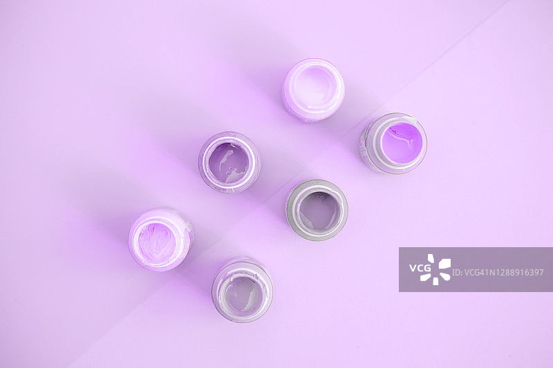 紫色背景上的什锦颜料罐图片素材