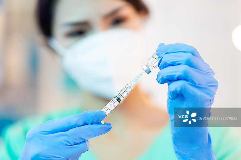 护士将疫苗注入注射器图片素材