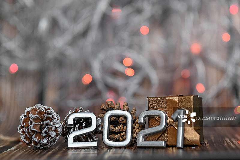 木质背景上的2021银色数字新年装饰，圣诞礼物图片素材