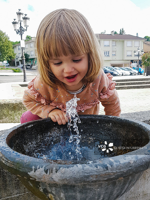 从喷泉喝水的可爱小女孩图片素材