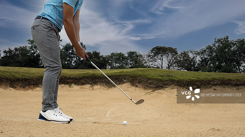 高尔夫球手从沙坑击球图片素材