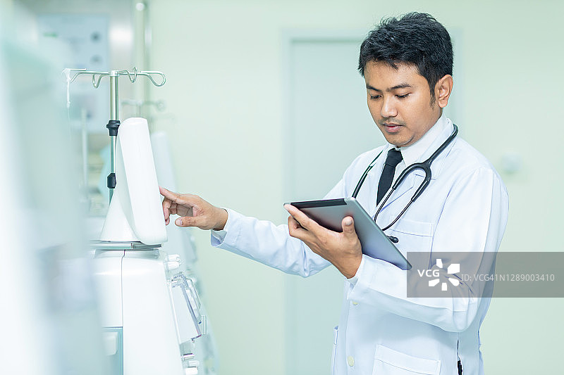 亚洲医疗保健：医生使用透析机和听诊器图片素材