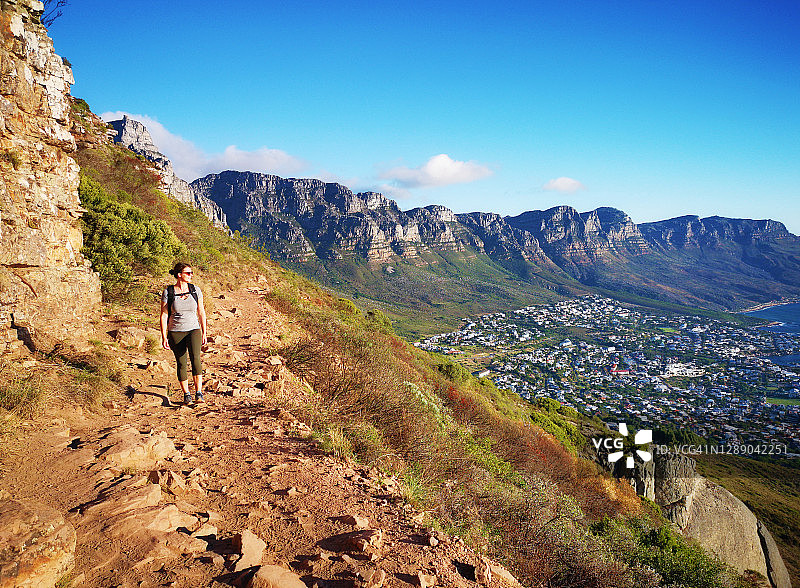 年轻女人在日落时独自徒步登上开普敦的狮头山图片素材