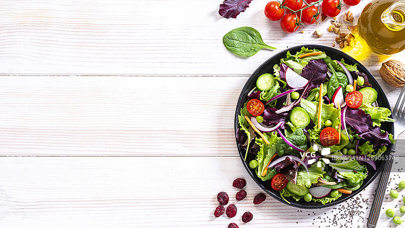 白色餐桌上的新鲜蔬菜沙拉盘，留白图片素材