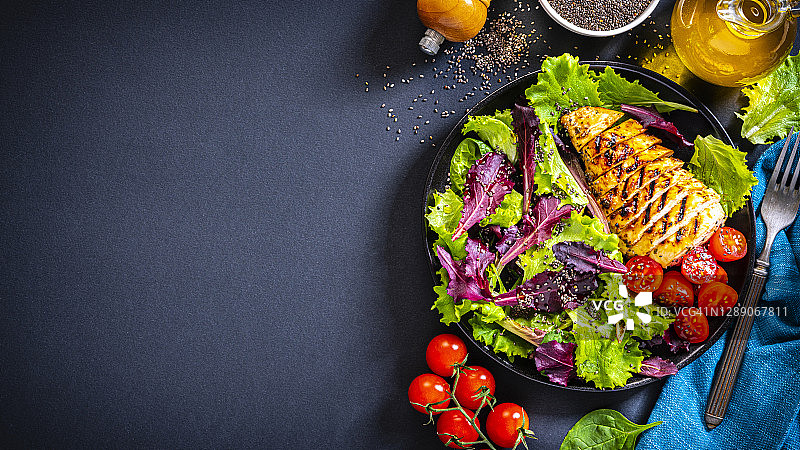 深色背景上的鸡肉沙拉拼盘俯视图，留有复制空间图片素材