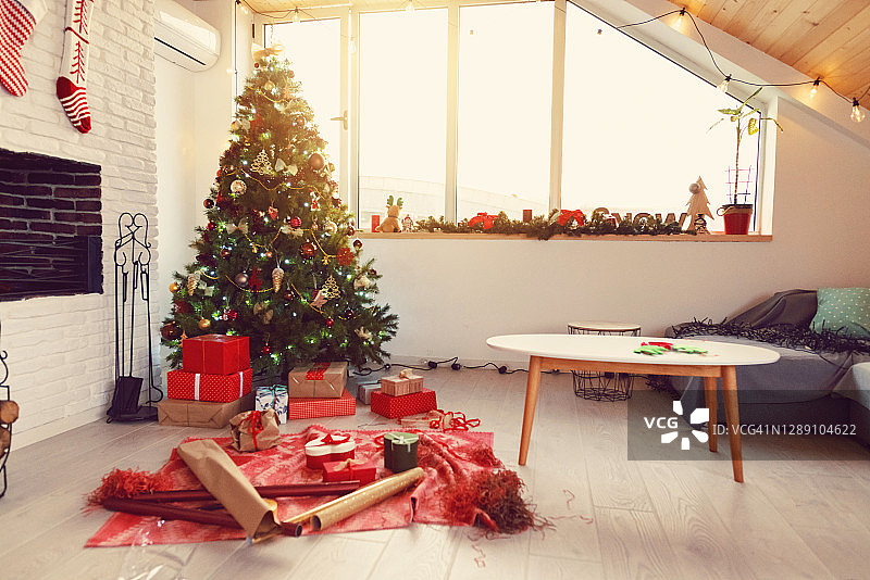 客厅里装饰着饰品和礼物的圣诞树图片素材
