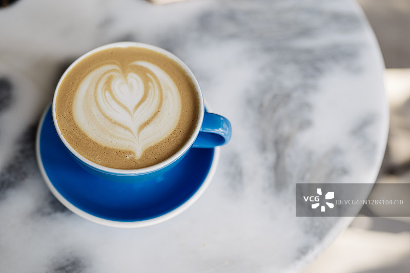 绿杯拿铁热咖啡顶视图，具有拉花艺术和烤咖啡豆图片素材