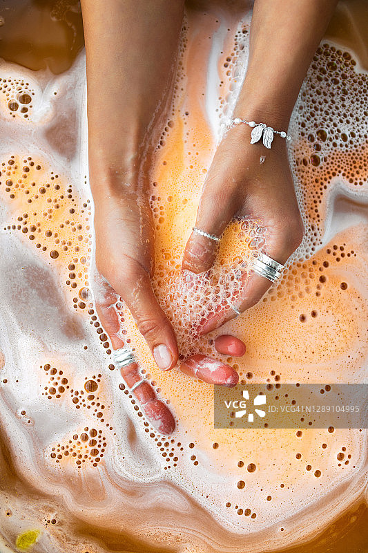 橙色浴盐弹在手中溶解图片素材