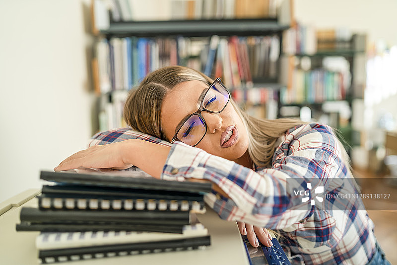 疲惫的女学生在复印机上睡觉图片素材