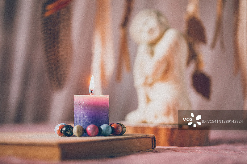 慈悲佛像、书籍和点燃的蜡烛图片素材