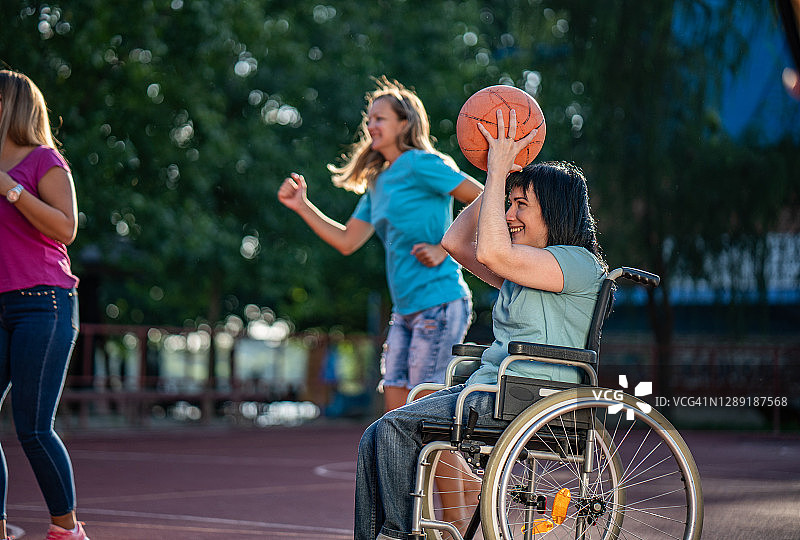 坐在轮椅上打篮球的女士图片素材