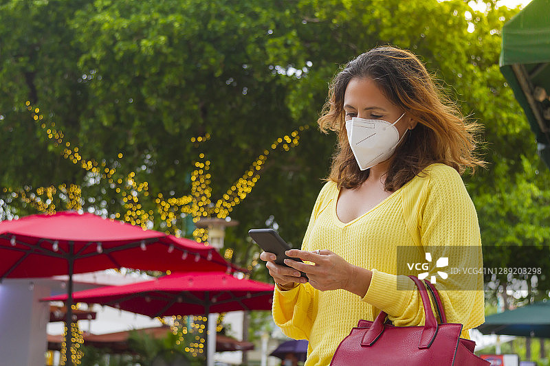 在佛罗里达州迈阿密海滩用手机发短信等出租车的年轻拉丁裔女人图片素材