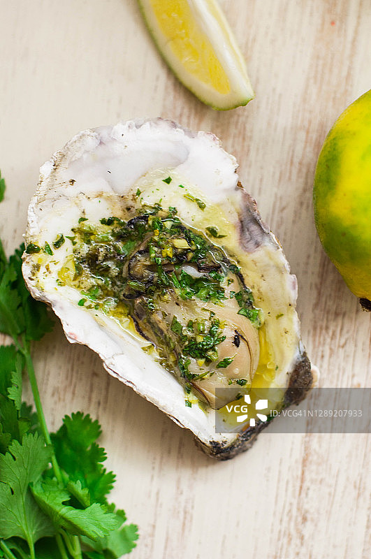 新鲜烤制的黄油牡蛎配青柠皮和香菜图片素材