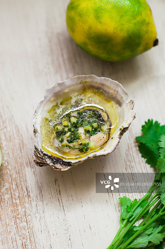 新鲜烤制的黄油牡蛎配青柠皮和香菜图片素材