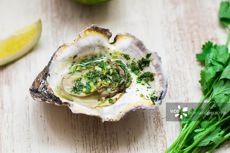 新鲜烤制的黄油牡蛎配青柠皮和香菜图片素材