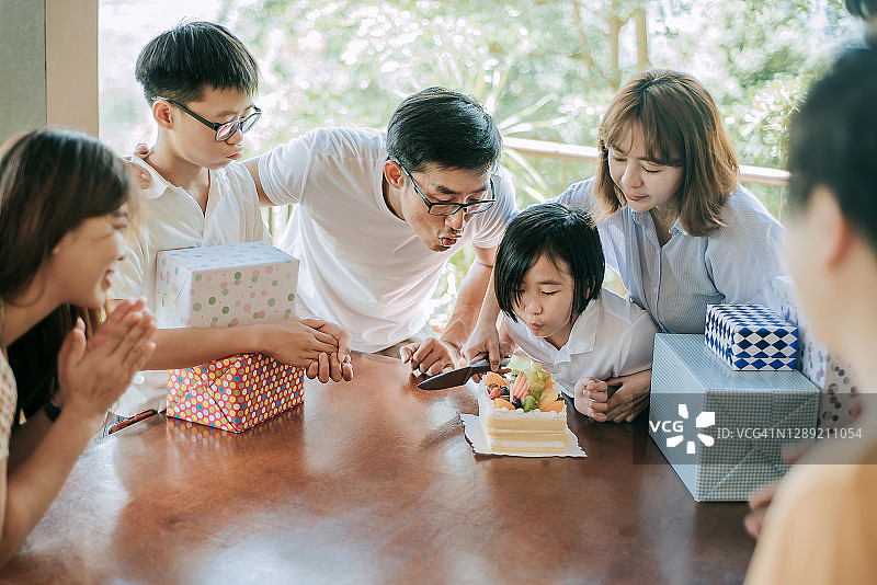 在别墅后院与家人庆祝生日的亚洲华人女孩图片素材
