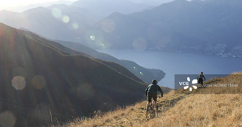 山地自行车手在清晨沿山脊骑行图片素材