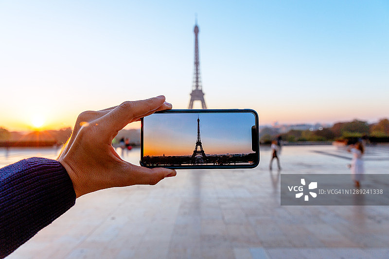 男人用手机拍摄巴黎埃菲尔铁塔图片素材