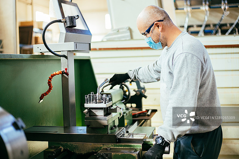 工人在金属制造公司的铣床上工作照片图片素材