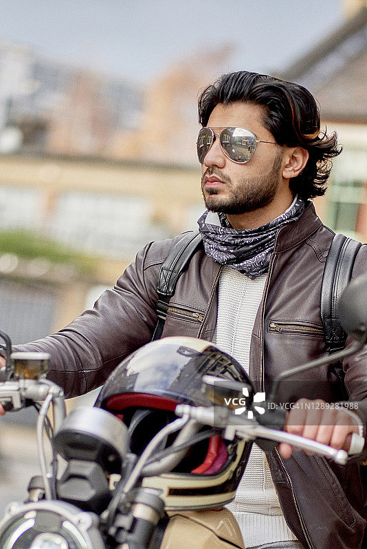 骑着电动摩托的酷炫年轻男子肖像图片素材