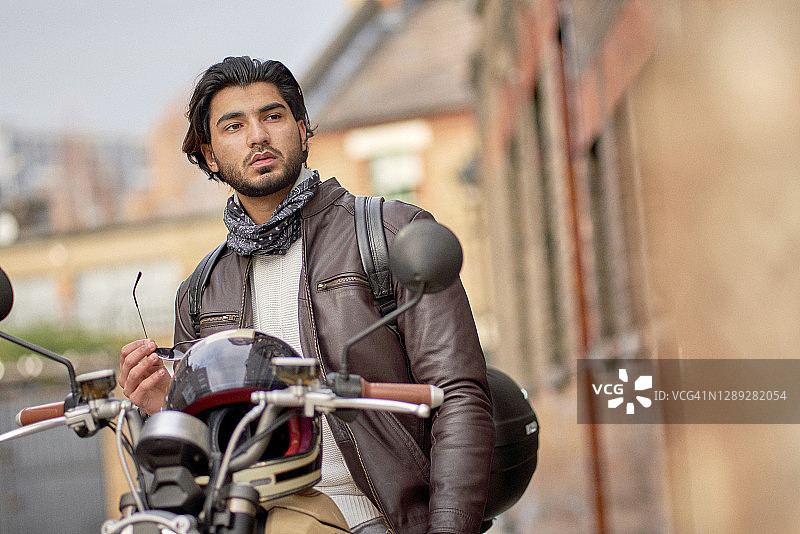骑着电动摩托的酷炫年轻男子肖像图片素材
