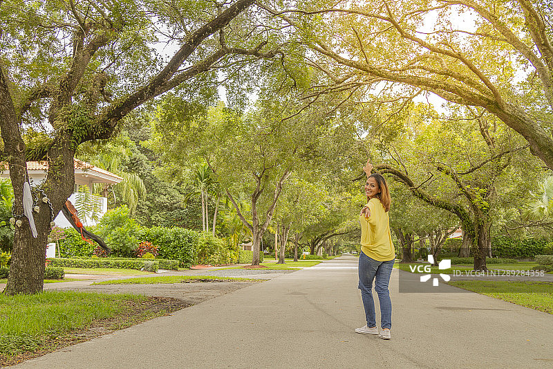 在美国佛罗里达州迈阿密珊瑚阁区树荫下旅行的年轻拉丁女人图片素材