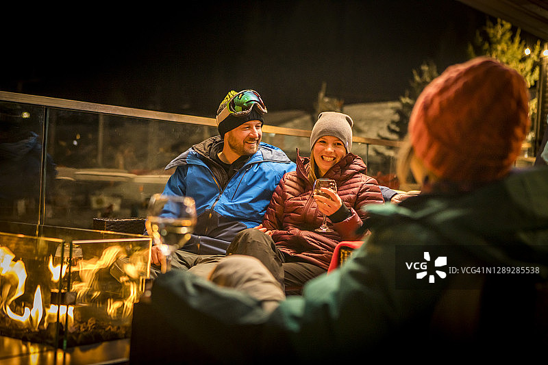夜晚，朋友们围坐在滑雪后的篝火旁图片素材