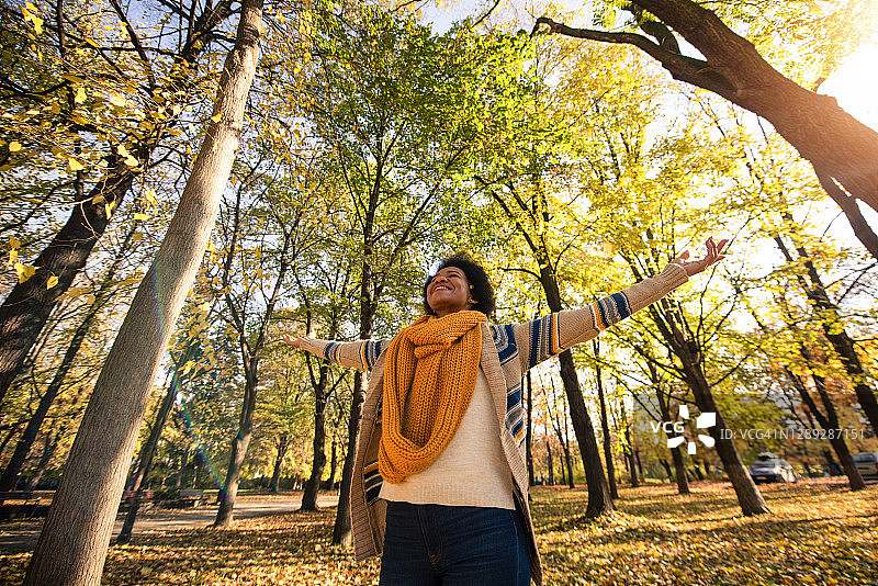 年轻黑人女人在秋日公园里做白日梦图片素材