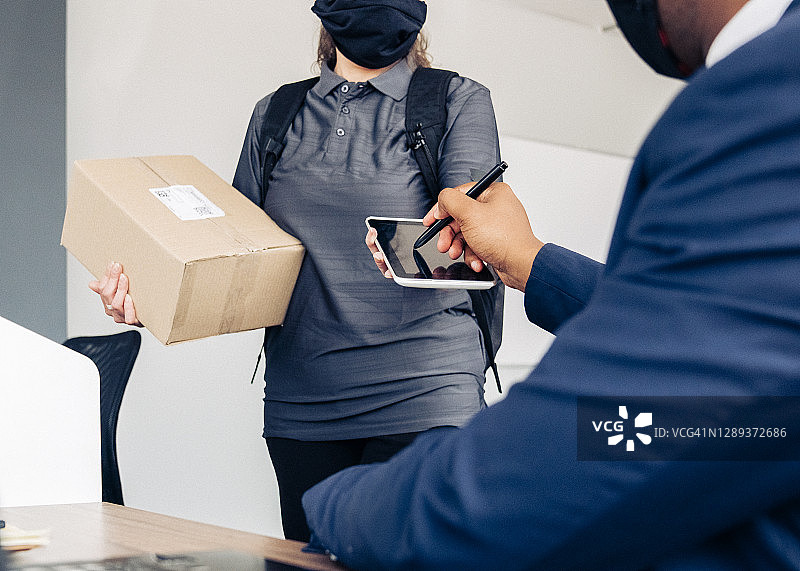 商人签署平板电脑的腰部特写图片素材