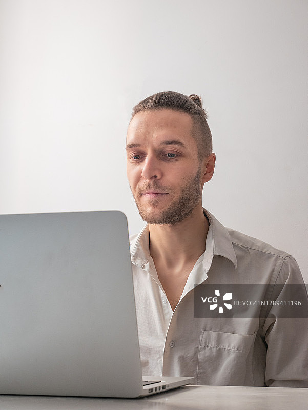 在隔离期间通过视频通话微笑的白人男子图片素材