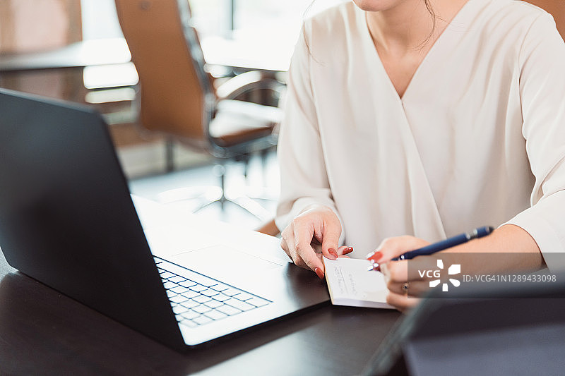 在视频会议中做笔记的女子图片素材