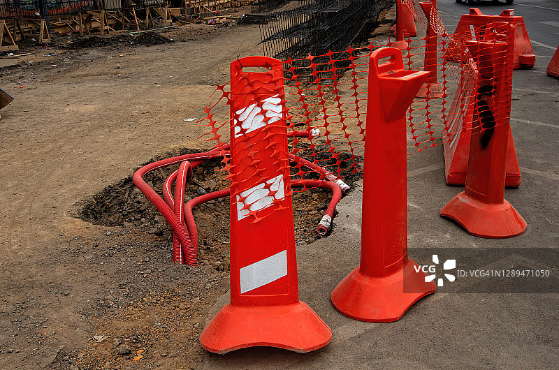 维修中街道路缘上的橙色塑料建筑屏障图片素材