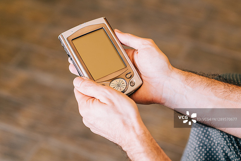 男人使用的老式PDA设备手部细节图片素材